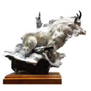 Bronze mountain goat in a white patina climbing through snowy rocks on a walnut base