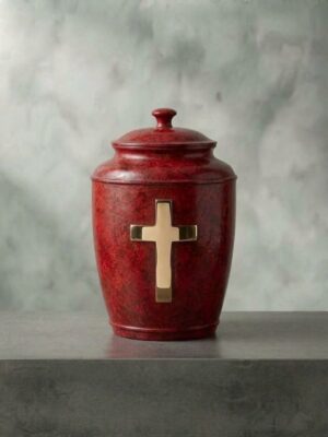Bronze cremation urn with a deep red patina and a polished gold-toned cross on the front, by Eric Thorsen